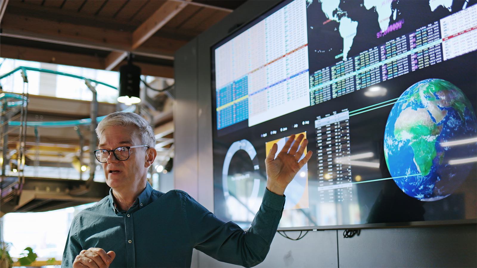 Man pointing at screen with data