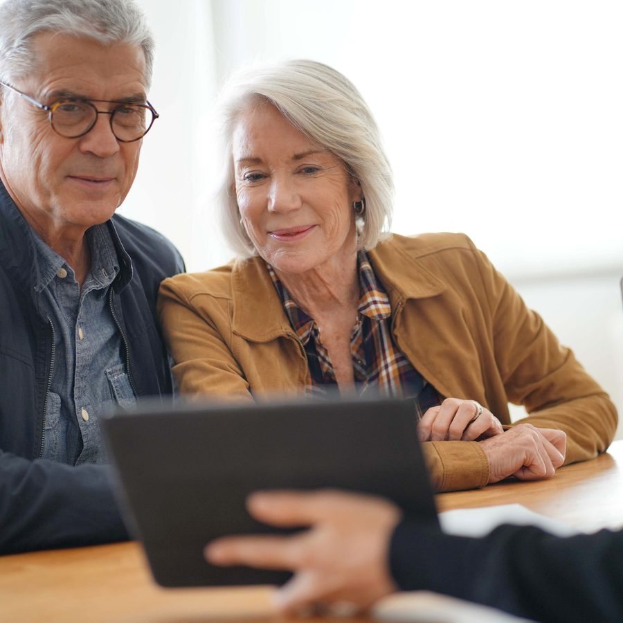 Elderly Couple Looking at a Table with Financial Advisor